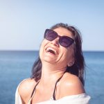 Portrait of a happy woman laughing at the sea